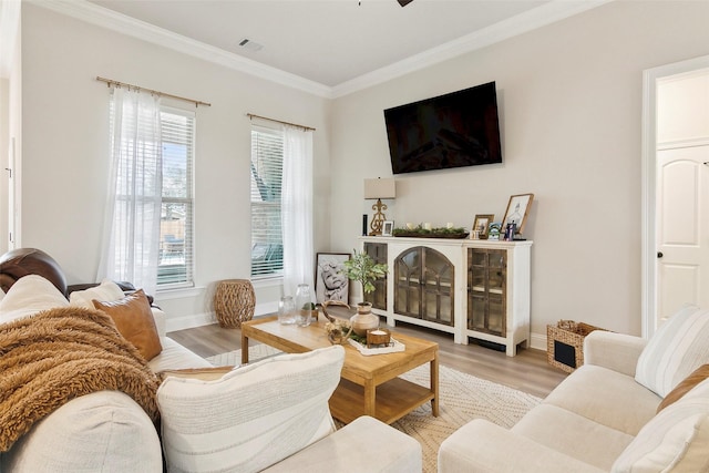 living room with crown molding, a fireplace, and light hardwood / wood-style floors