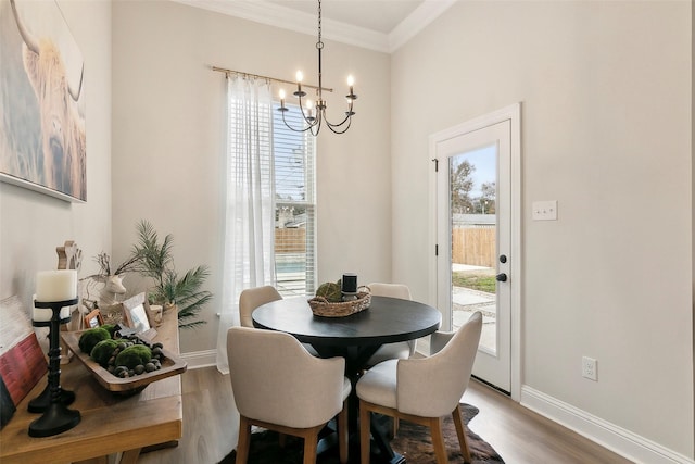 dining area featuring hardwood / wood-style floors, crown molding, and a chandelier