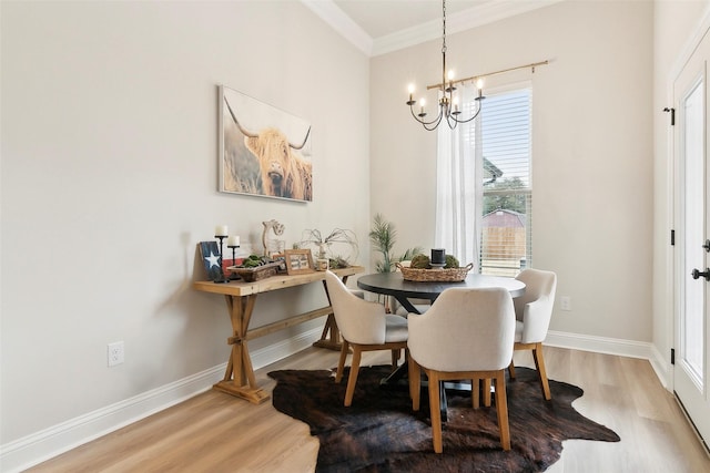 dining space with crown molding, hardwood / wood-style floors, and a notable chandelier