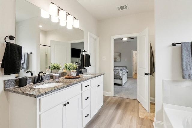 bathroom featuring vanity, hardwood / wood-style floors, and a bathtub