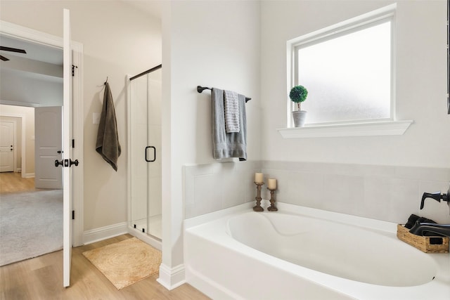 bathroom with hardwood / wood-style flooring and separate shower and tub