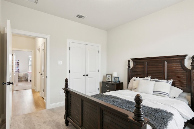 bedroom with light colored carpet and a closet