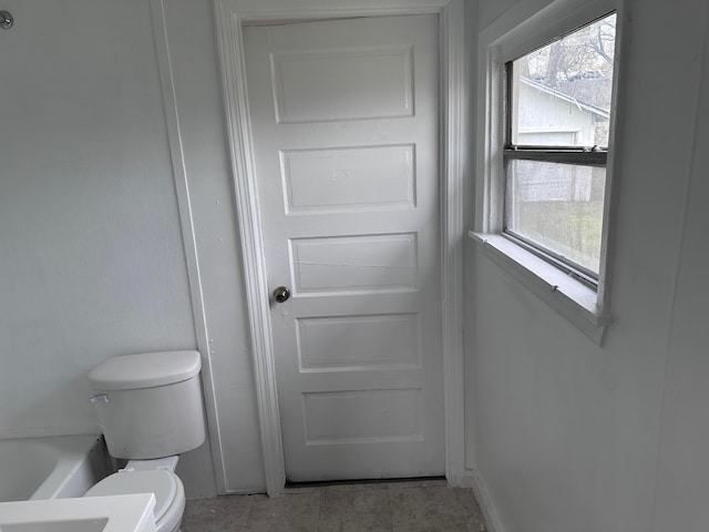 1006 9th St, Galena Park, TX 77547 - bathroom with plenty of natural light, tile patterned floors, a bathing tub, and toilet