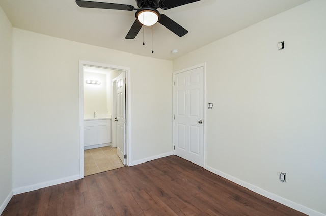 unfurnished bedroom featuring hardwood / wood-style flooring, ceiling fan, and connected bathroom