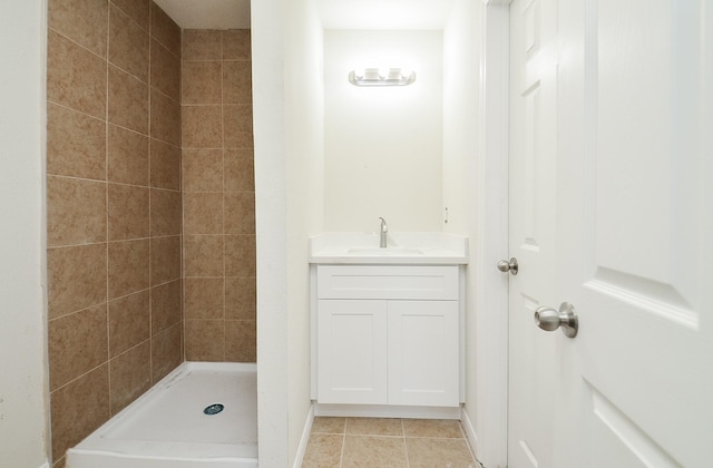 bathroom featuring vanity, a tile shower, and tile patterned floors