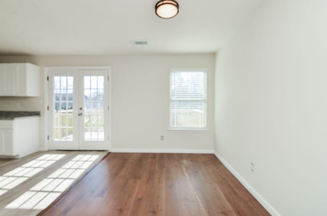 unfurnished room featuring french doors and hardwood / wood-style floors