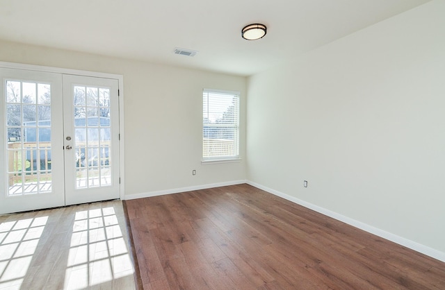 empty room with wood-type flooring and french doors