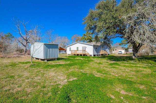 view of yard featuring a deck and a storage shed