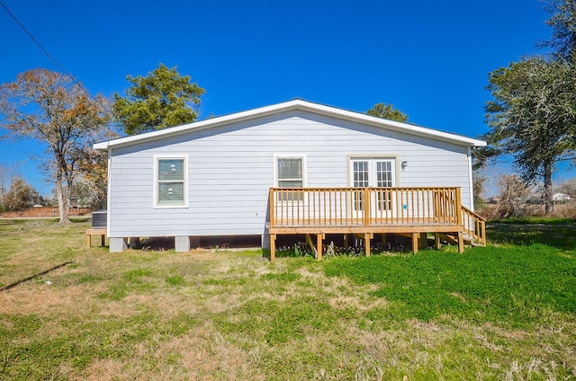 rear view of house featuring a yard, a deck, and central air condition unit