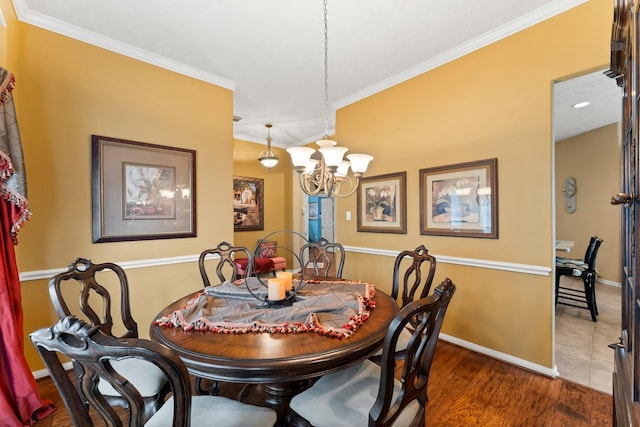 dining area with ornamental molding, dark hardwood / wood-style flooring, and a chandelier