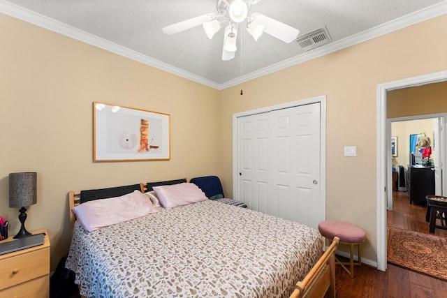 bedroom featuring crown molding, dark hardwood / wood-style floors, ceiling fan, and a closet