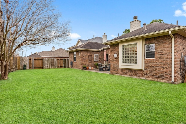 back of house featuring a yard and a patio area