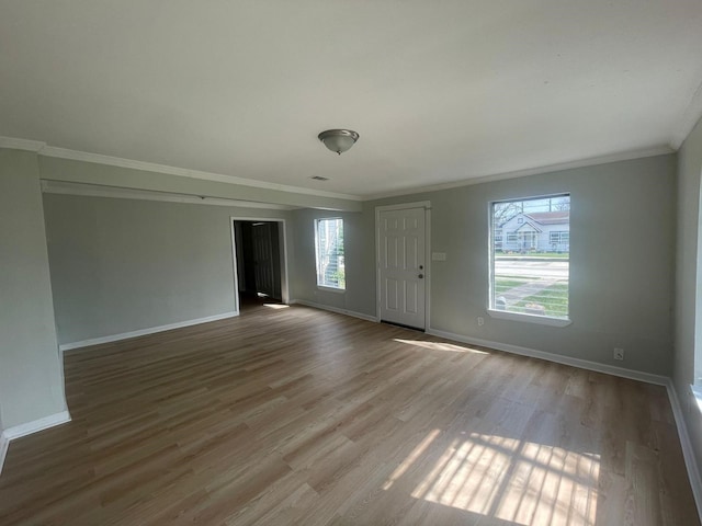 empty room featuring crown molding and wood-type flooring