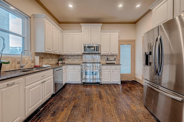 kitchen featuring white cabinetry, appliances with stainless steel finishes, sink, and ornamental molding