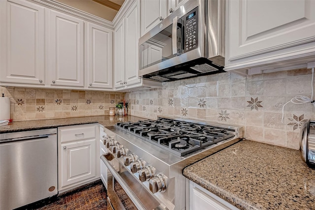 kitchen with stainless steel appliances, tasteful backsplash, white cabinets, and light stone counters