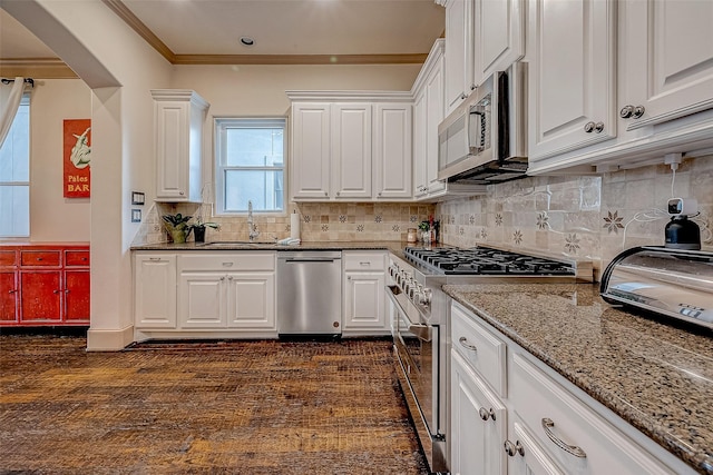 kitchen with white cabinetry, stainless steel appliances, crown molding, and decorative backsplash