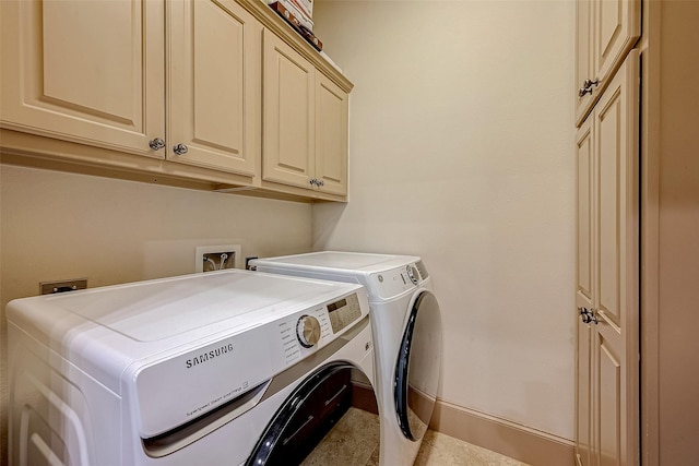 clothes washing area featuring cabinets and washer and clothes dryer