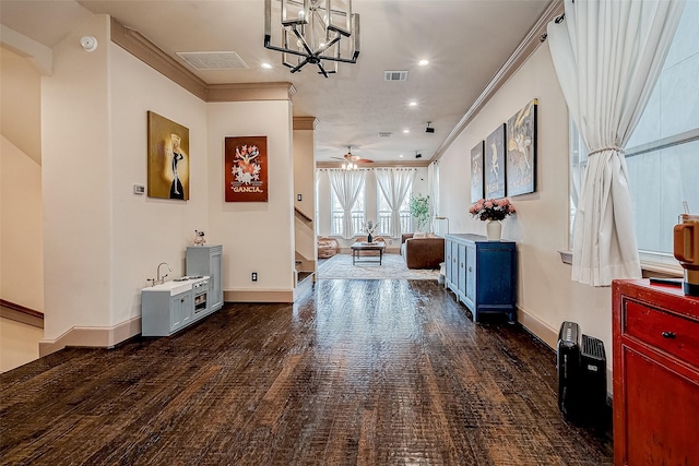 hallway with ornamental molding and a chandelier