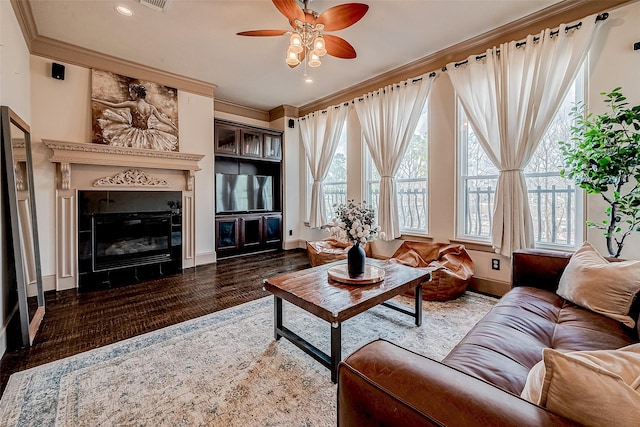 living room featuring ceiling fan, ornamental molding, and dark hardwood / wood-style flooring