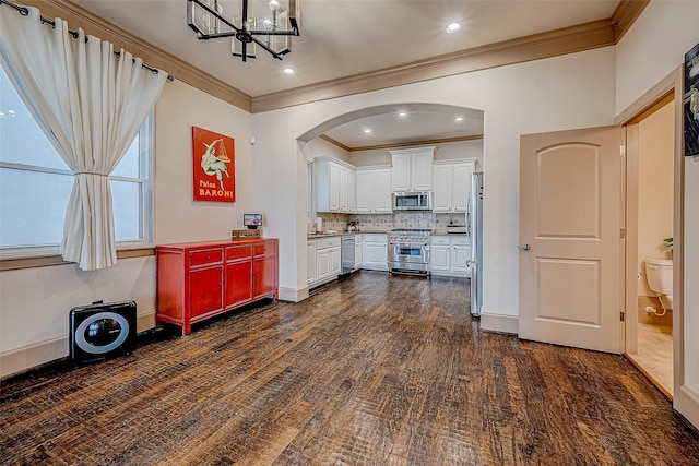 kitchen featuring dark wood-type flooring, white cabinetry, tasteful backsplash, a notable chandelier, and stainless steel appliances