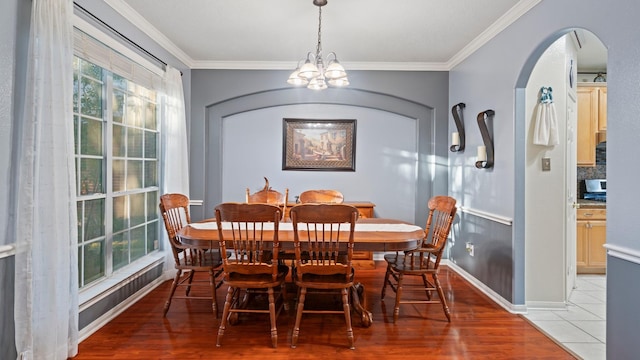 dining room with ornamental molding, a chandelier, and light hardwood / wood-style floors