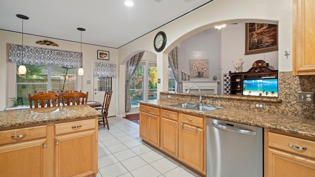 kitchen with sink, decorative backsplash, stone countertops, decorative light fixtures, and stainless steel dishwasher