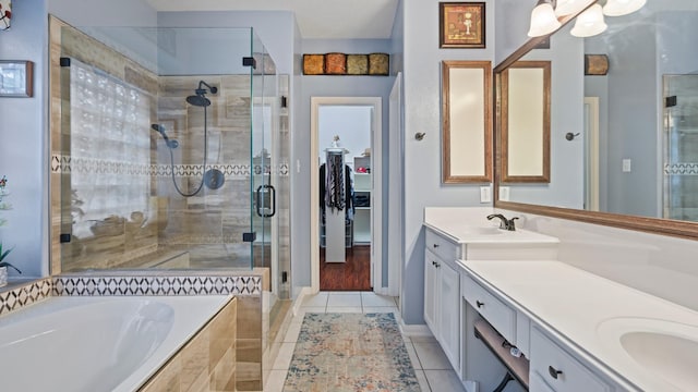 bathroom with double vanity, a sink, tile patterned flooring, a shower stall, and a garden tub