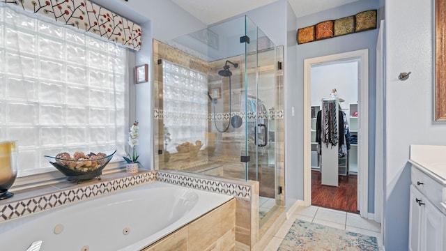 bathroom featuring vanity, a shower stall, a jetted tub, and tile patterned floors