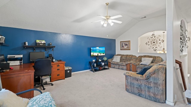 carpeted office space featuring lofted ceiling, baseboards, visible vents, and ceiling fan