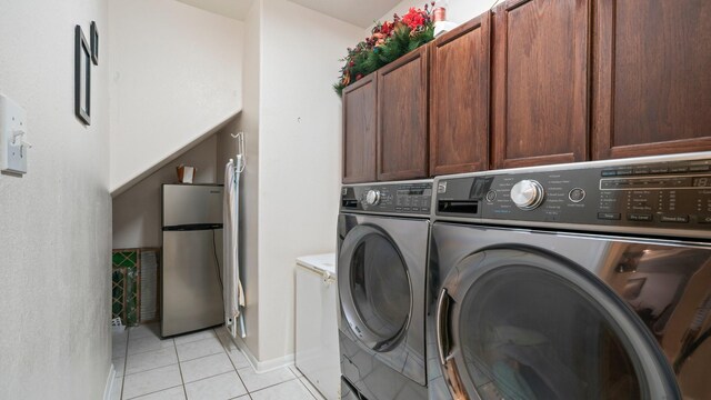 washroom featuring separate washer and dryer, cabinets, and light tile patterned flooring