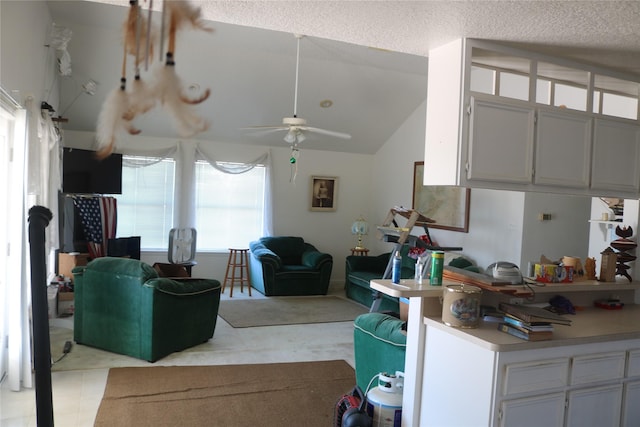 living room featuring vaulted ceiling, a textured ceiling, and ceiling fan