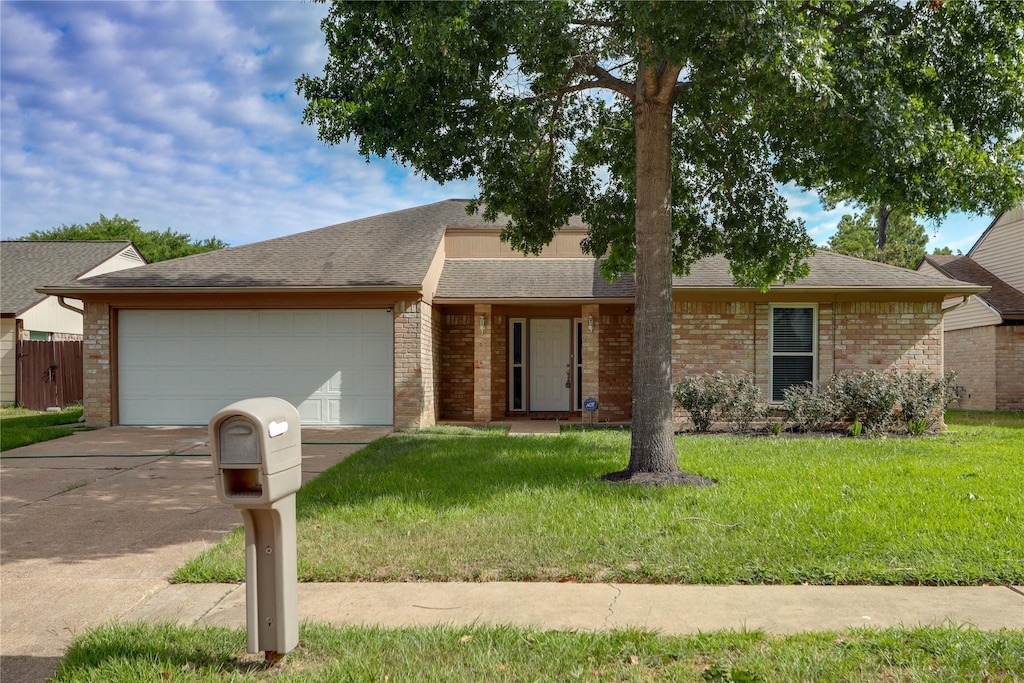 single story home featuring a garage and a front lawn