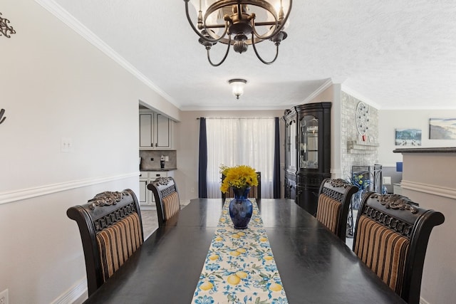 dining area with a textured ceiling, ornamental molding, a chandelier, and a fireplace