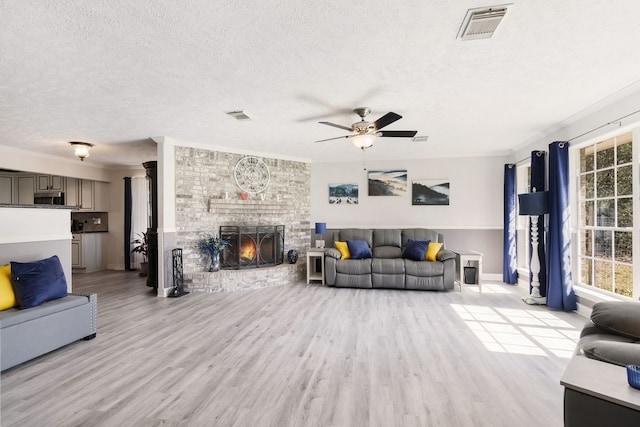 living room featuring light hardwood / wood-style floors, a wealth of natural light, and ornamental molding