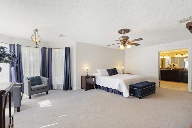 bedroom featuring a textured ceiling, connected bathroom, ceiling fan, light carpet, and multiple windows