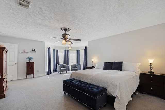 bedroom with a textured ceiling, ceiling fan, and light colored carpet