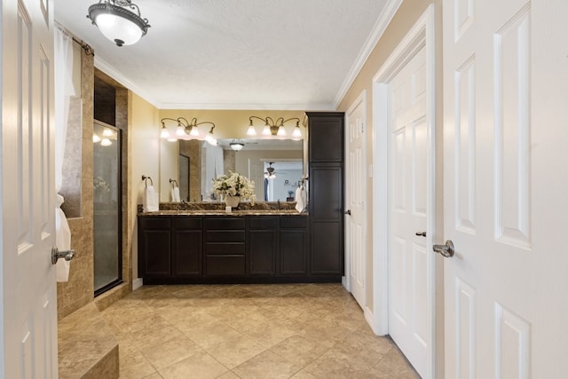 bathroom featuring ornamental molding, an enclosed shower, and vanity