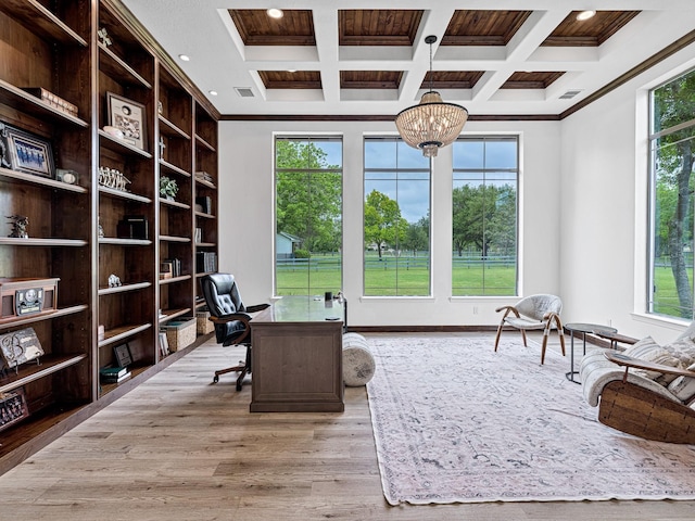 home office featuring coffered ceiling, a notable chandelier, crown molding, and light hardwood / wood-style floors