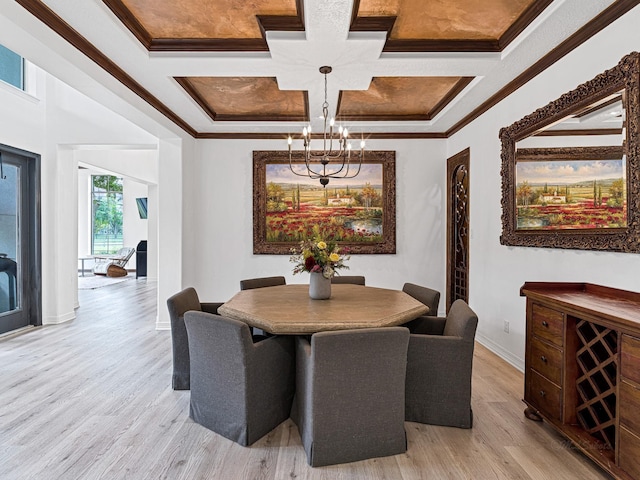 dining area featuring crown molding, coffered ceiling, an inviting chandelier, and light hardwood / wood-style flooring