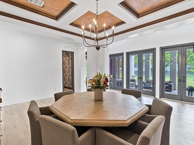 dining room with coffered ceiling, light hardwood / wood-style flooring, an inviting chandelier, and french doors