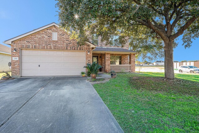 view of front of property featuring a porch, a garage, and a front lawn