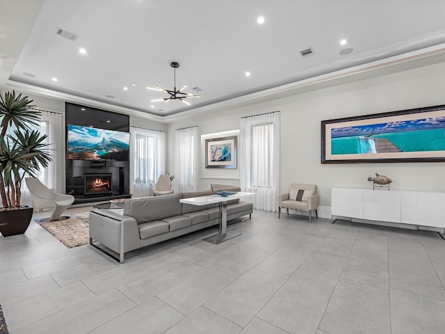 living room with light tile patterned floors, a notable chandelier, and a raised ceiling