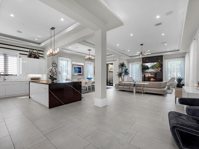 kitchen featuring a spacious island, a tray ceiling, hanging light fixtures, and a wealth of natural light