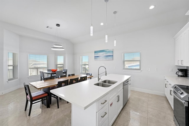 kitchen featuring sink, decorative light fixtures, stainless steel appliances, and a center island with sink