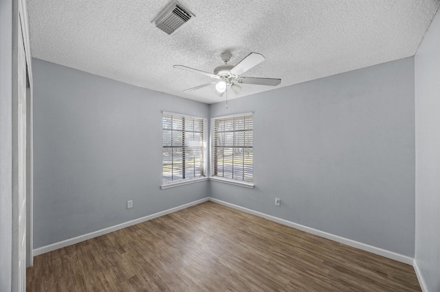 empty room featuring ceiling fan, wood-type flooring, and a textured ceiling