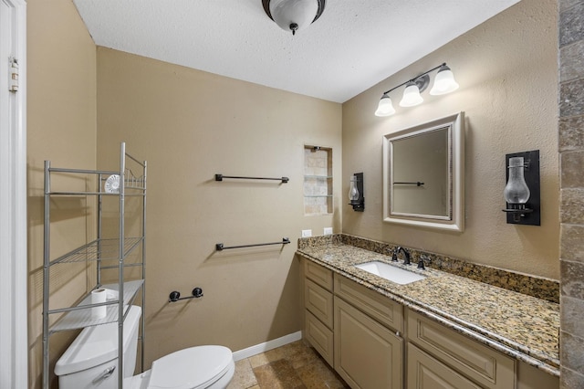 bathroom with vanity, a textured ceiling, and toilet