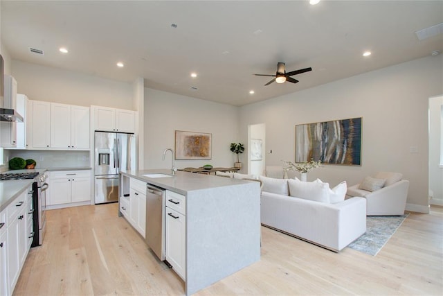 kitchen with white cabinetry, sink, a center island with sink, and appliances with stainless steel finishes