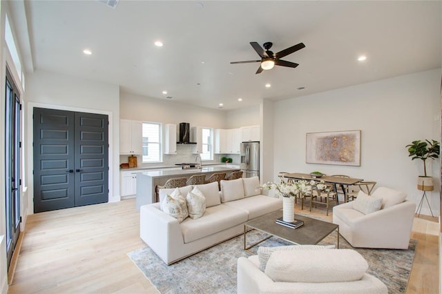 living room featuring ceiling fan and light hardwood / wood-style floors