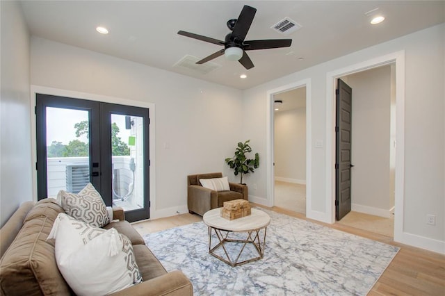 living room with light hardwood / wood-style flooring, ceiling fan, and french doors