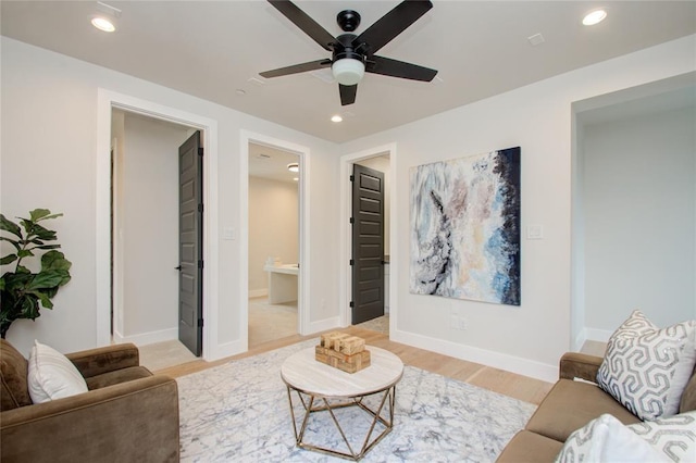 living room with ceiling fan and light hardwood / wood-style floors